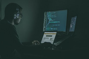 man sitting in front of computer wearing headphones